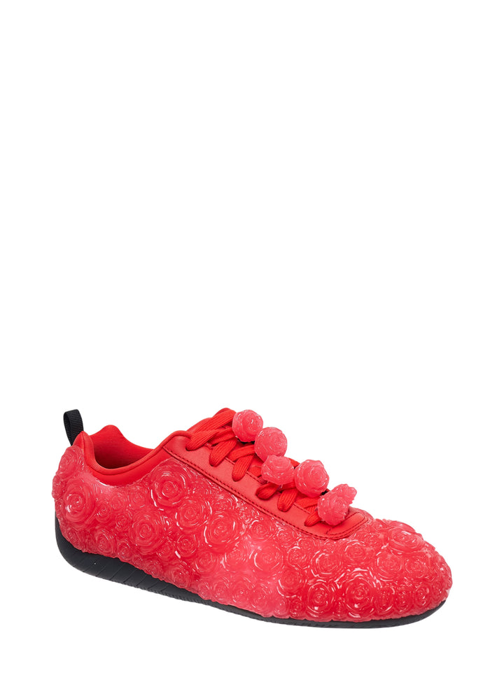 Noir Kei Ninomiya red low-top sneaker with translucent embossed rose details, rose-shaped lace toggles and a black rubber sole, shown in side profile - view 2