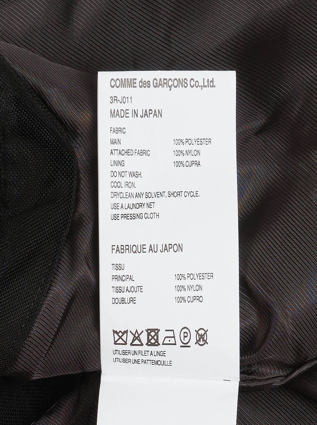 Noir Kei Ninomiya black oversized long sleeve jacket with high drawstring neck, silver zip closures, angled chest zip pockets, and layered black tulle ruffle hem, displayed flat on a white background - view 3