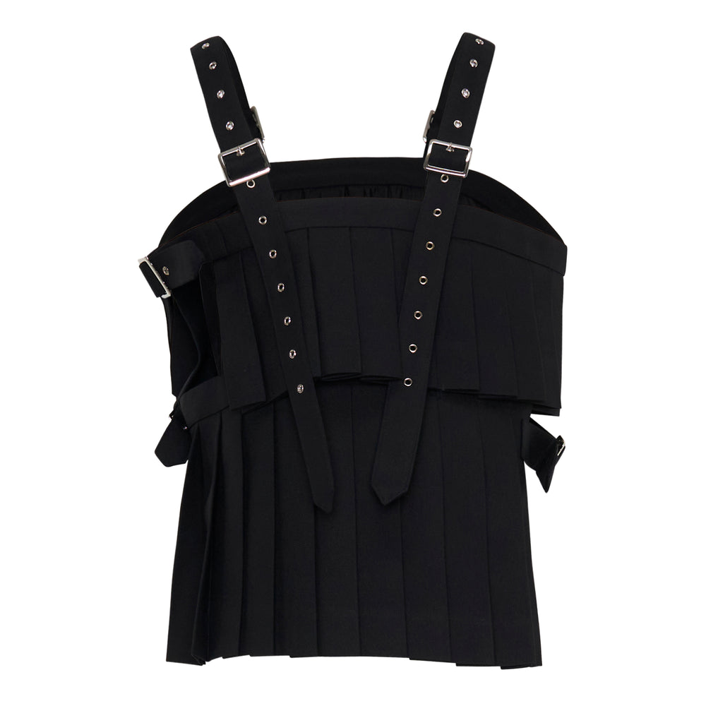 Noir Kei Ninomiya black pleated vest with adjustable silver buckle shoulder straps, eyelet hardware detail, and draped chest overlay on a white background