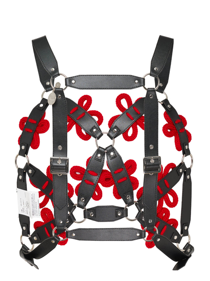 Black faux leather harness vest with red knitted floral appliqués, silver ring connectors and adjustable buckles by Noir Kei Ninomiya - view 2
