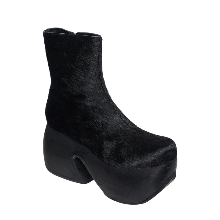 Comme des Garçons x John Fluevog black pony hair platform ankle boot with sculptural cut-out heel, side view on white background