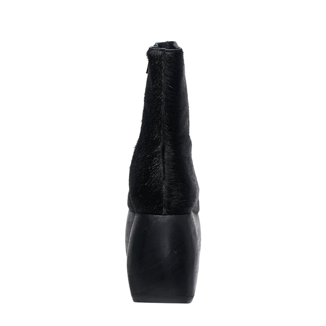 Comme des Garçons x John Fluevog black pony hair platform ankle boot with sculptural cut-out heel, side view on white background