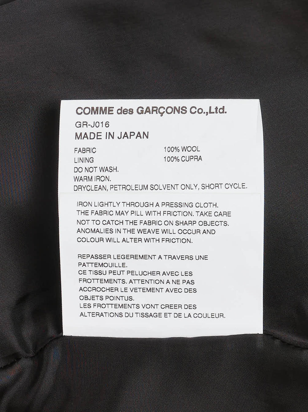 Comme des Garçons black sculptural asymmetric blazer with deconstructed layered lapels, mother-of-pearl buttons, and asymmetric hem revealing satin lining, photographed flat on white background - view 4