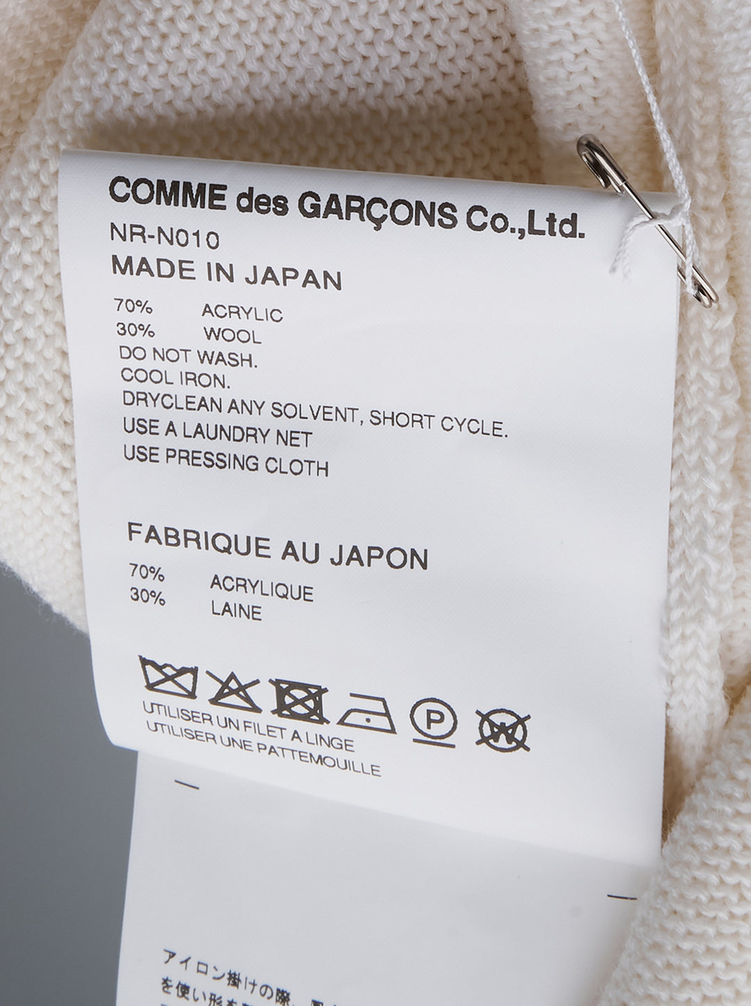 Comme des Garçons Girl ivory long sleeve fine knit top with 3D crochet unicorn appliqué in white and pink on the chest, crew neckline, flat lay on white background - view 3