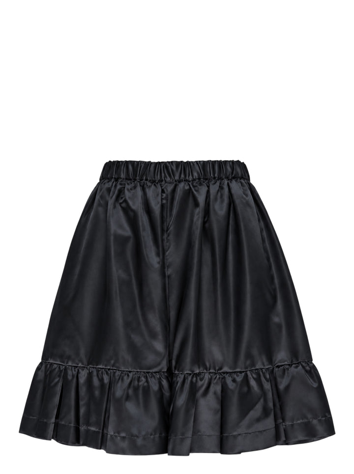 Comme des Garçons Girl black satin shorts with elasticated ruched waistband, gathered silhouette, and tiered ruffle hem, shot flat on a white background