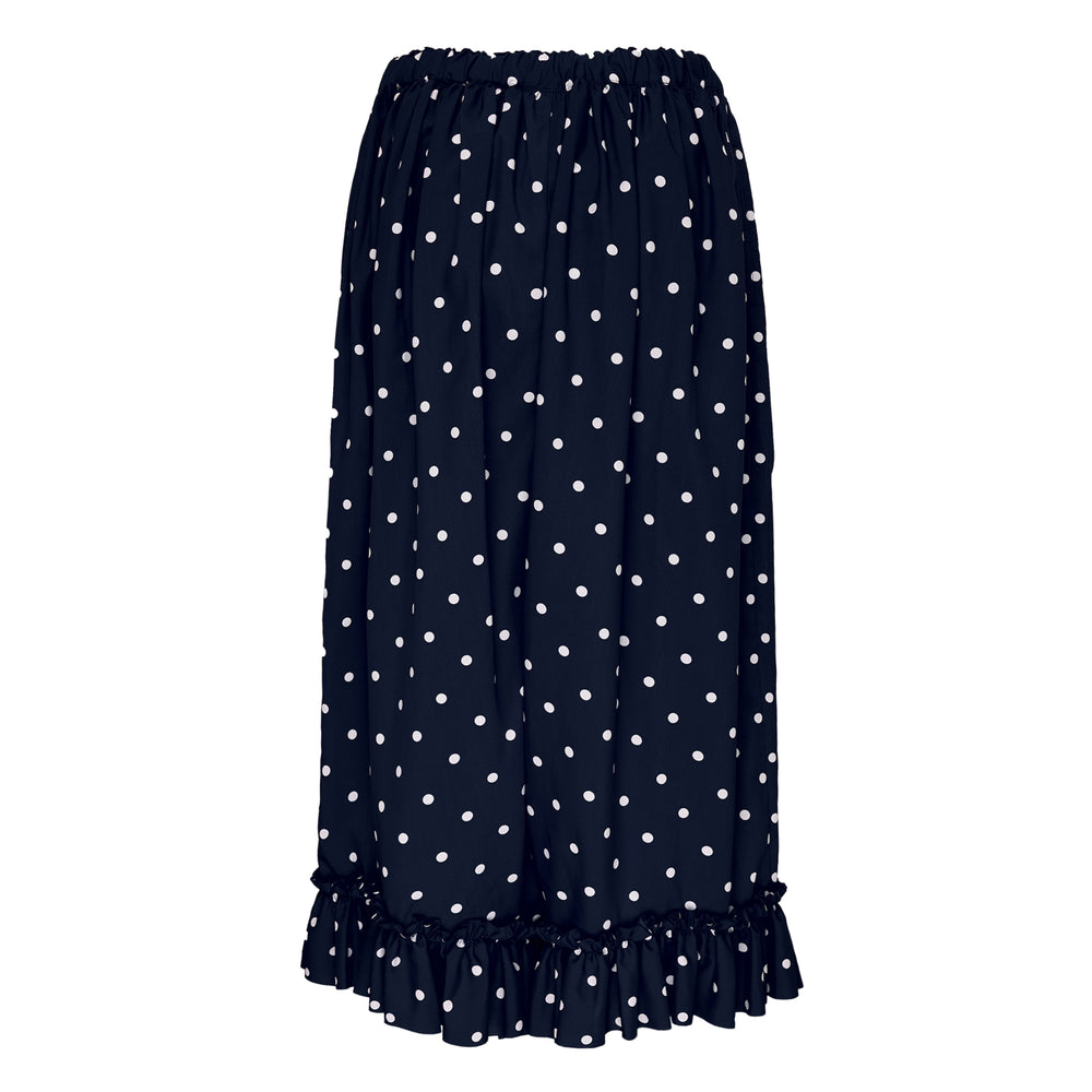 Comme des Garçons Girl navy wide-leg pants with white polka dot print, elasticated gathered waist, and ruffled frill hem, displayed flat on a white background