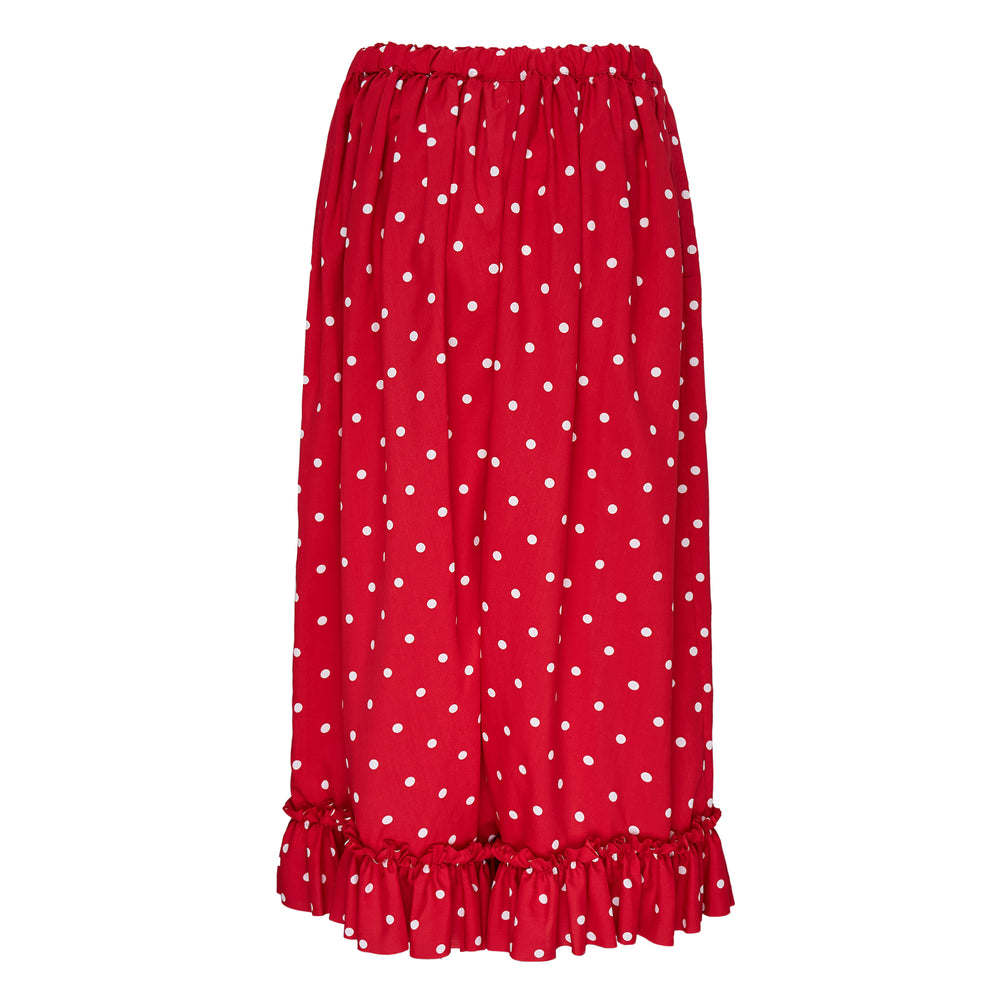 Comme des Garçons Girl navy wide-leg pants with white polka dot print, elasticated gathered waist, and ruffled frill hem, displayed flat on a white background