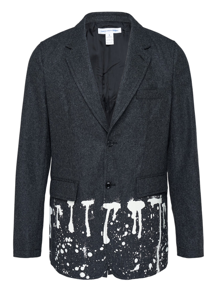 Comme des Garçons Shirt charcoal wool blazer with notched lapels, two-button closure and white paint-drip print along the hem