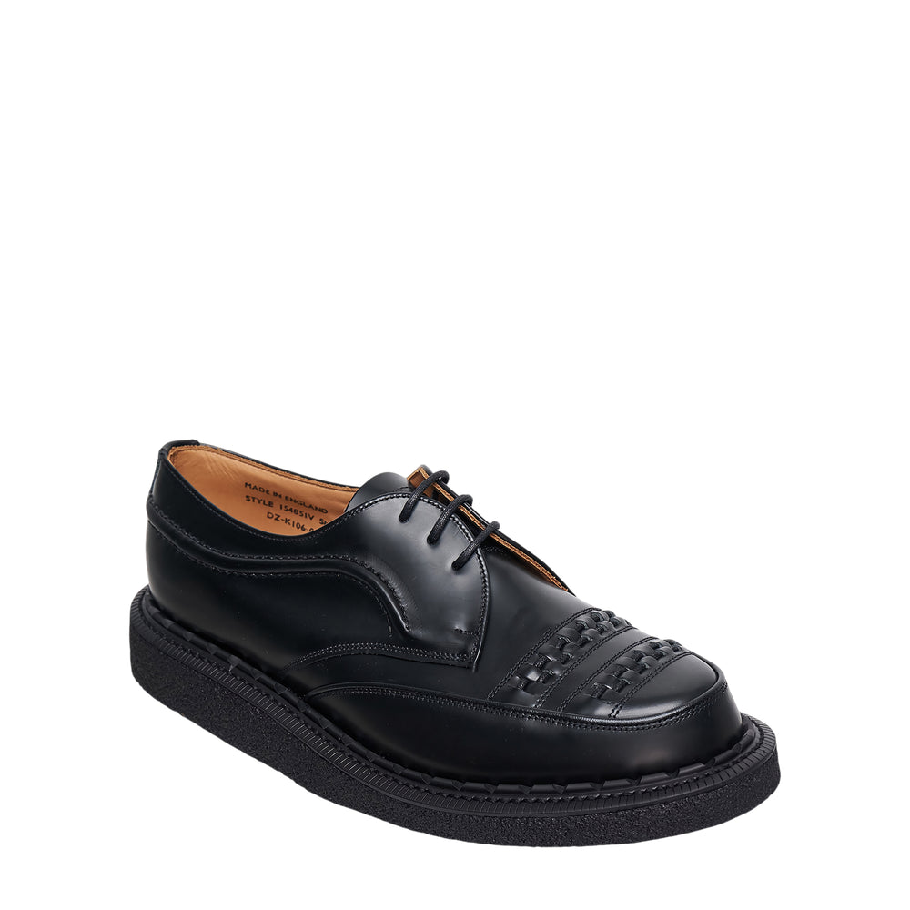 Comme des Garçons Homme Deux x George Cox Tench Derby shoe in polished black leather with woven cap toe and thick black crepe sole, side profile view