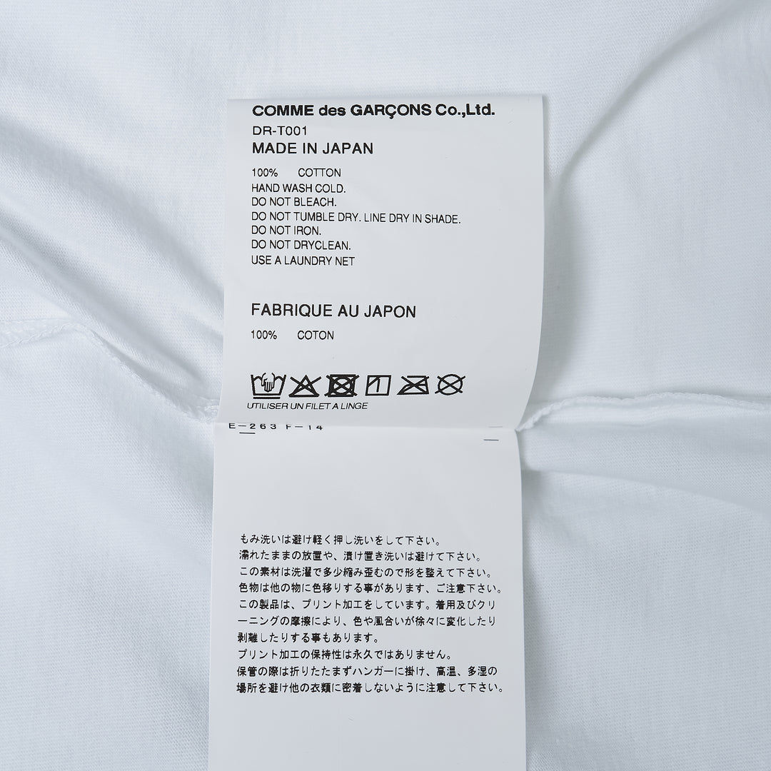 Comme des Garçons Homme Deux white cotton jersey tee with large abstract graphic print featuring two humanoid figures in teal and red on the chest
