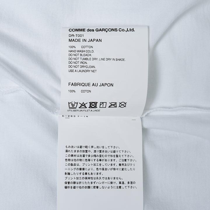 Comme des Garçons Homme Deux white cotton jersey tee with large abstract graphic print featuring two humanoid figures in teal and red on the chest