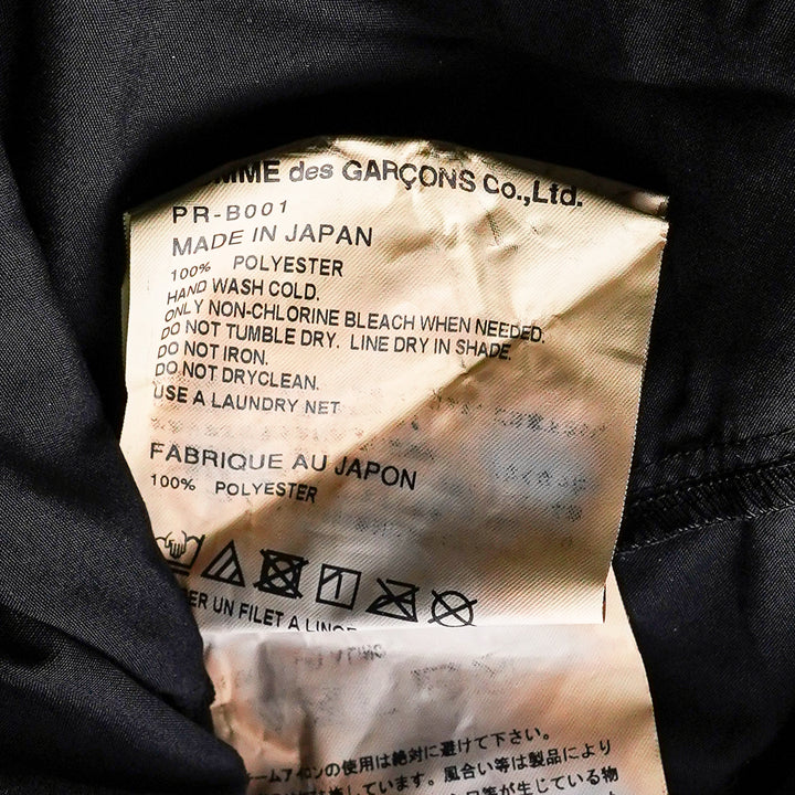 Comme des Garçons Homme Plus black long sleeve shirt with draped and gathered fabric panel at the front torso, silver-tone buttons, point collar, and extended hem with vent - view 3