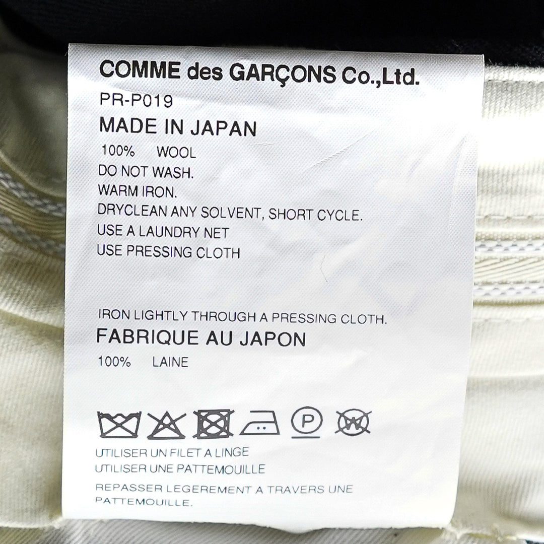 Comme des Garçons Homme Plus black double weave wool wide-leg shorts with deep pleats, button fly, and folded turn-up cuffs, shown flat on white background - view 3
