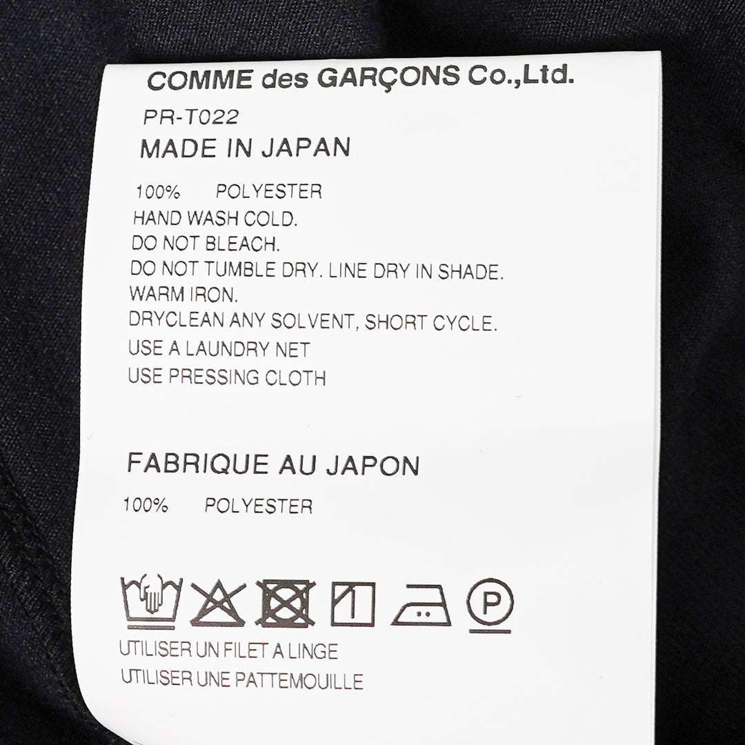 Comme des Garçons Homme Plus black long-sleeve polyester jersey tee with sculptural curved overlay bib panel and open split hem, displayed flat on white background - view 3