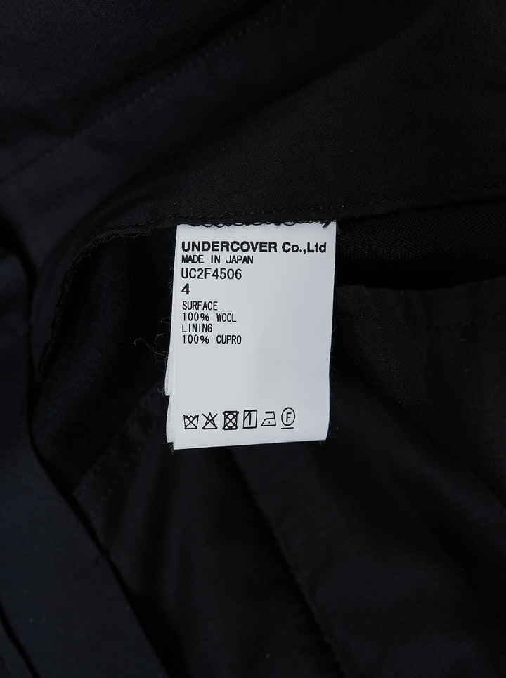 Undercover Cindy Sherman Patch Trousers in black, front view showing straight-leg tailored cut with pressed crease and patch detail - view 4