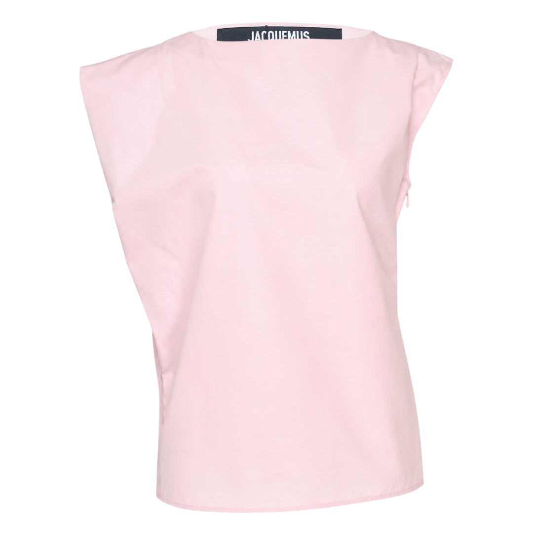 Jacquemus La Haut Drap sleeveless woven top in pale pink with structured shoulder seams, side zip detail, and navy brand label at the neckline