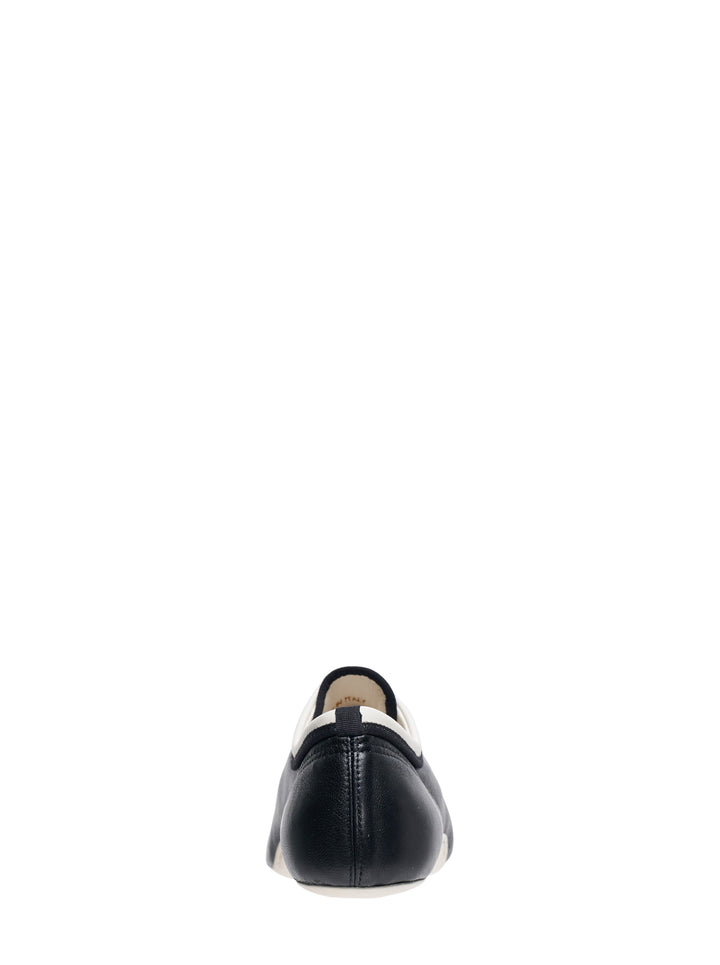 Dries Van Noten foot-shaped black leather lace-up flat shoe with white rubber sole and contrast white collar trim, side profile view - view 3