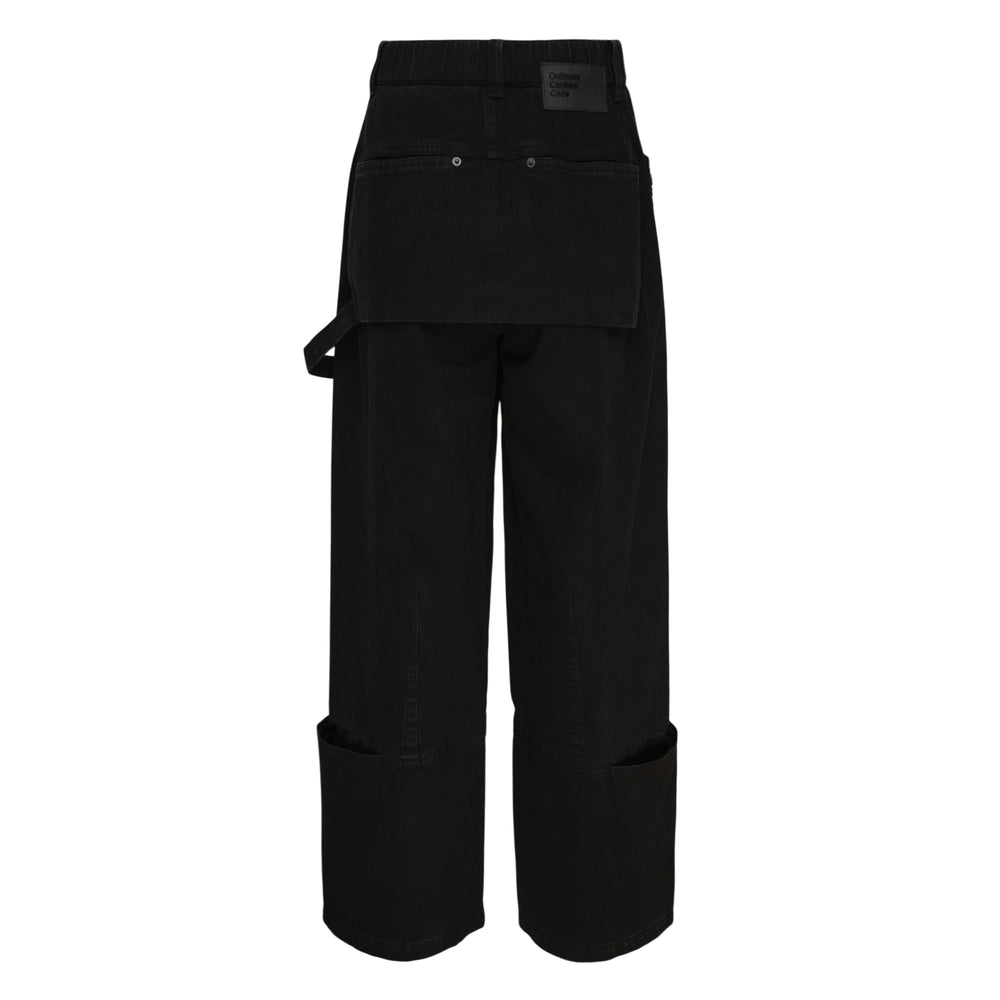 Ordinary Couture Code black wide-leg denim jeans with kangaroo front pocket, carpenter strap detail, and cuffed hem, displayed flat on white background