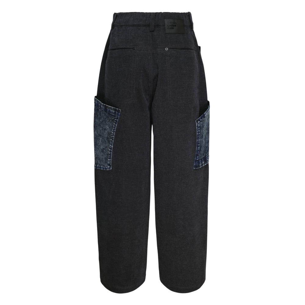 Ordinary Couture Code wide-leg high-rise jeans in washed black denim with oversized acid-wash blue patchwork panels featuring raw frayed edges, front view on white background