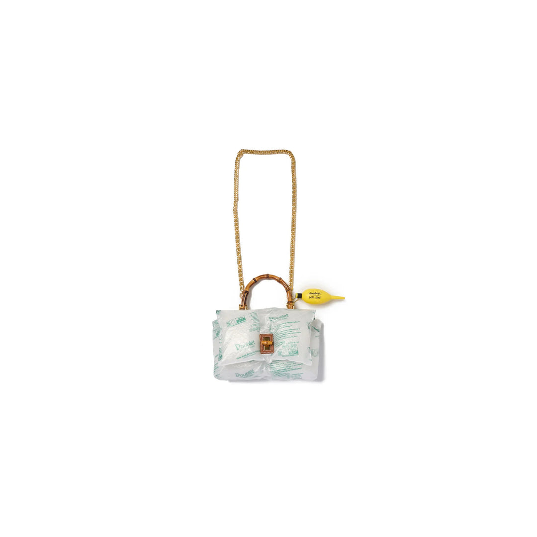 doublet Air Pillow Bamboo Handle Bag wrapped in inflatable air cushions with a gold chain strap, bamboo handle, tan leather turn-lock and yellow air pump charm