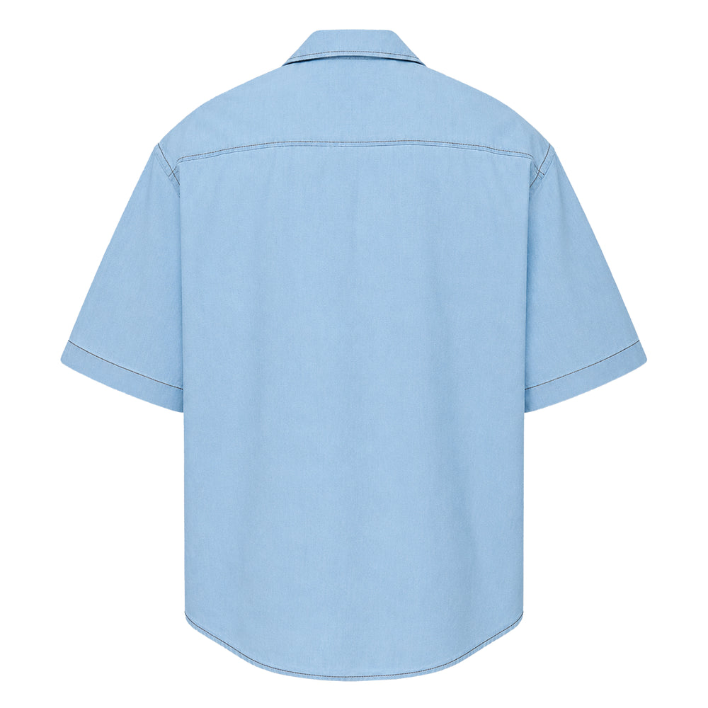 Ami Alexandre Mattiussi Short Sleeve Boxy Shirt in light blue chambray with contrast topstitching, camp collar, chest pocket, and Ami de Cœur logo embroidery