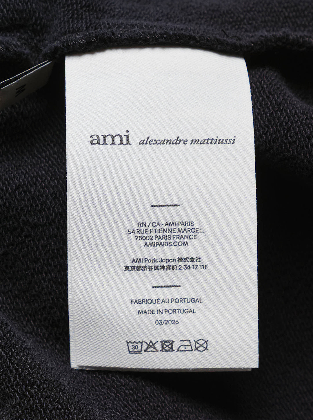 AMI black drawstring sweatpants with ribbed waistband and wide straight leg, shown from the front - view 4