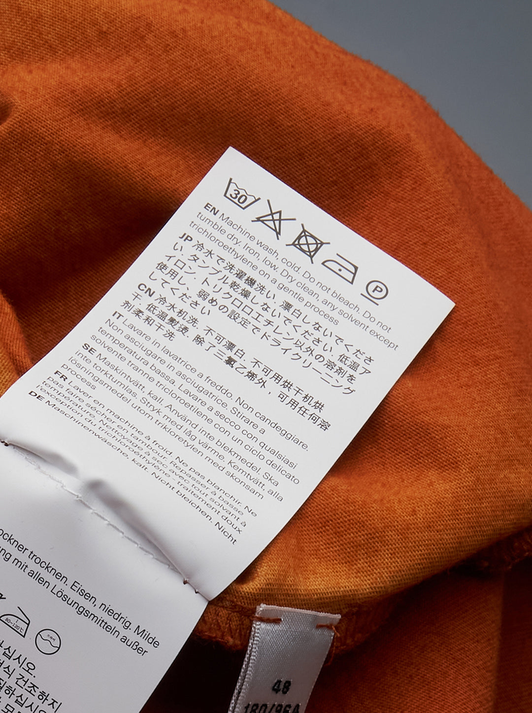 Our Legacy Cruise Long Sleeve Tee in an all-over orange and sand tie-dye wash, featuring a crew neck and contrast ribbed cuffs and hem, photographed flat on a white background - view 3