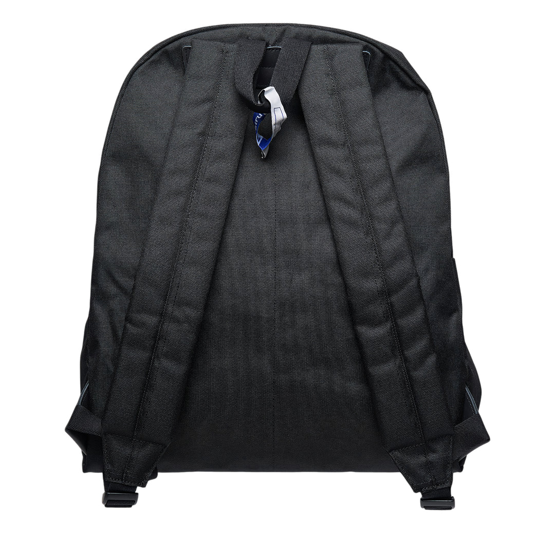 Mihara Yasuhiro in·stru(men·tal). large backpack in black canvas, front view showing zip closure, front pocket, woven brand label, and signature information-card patch with barcode and QR code detail