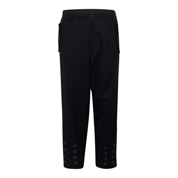 Yohji Yamamoto Hem Slit Button Pants in black, featuring tonal button-detailed hem slits at both ankles and side patch pockets with button-tab hardware, cropped tailored silhouette on white background