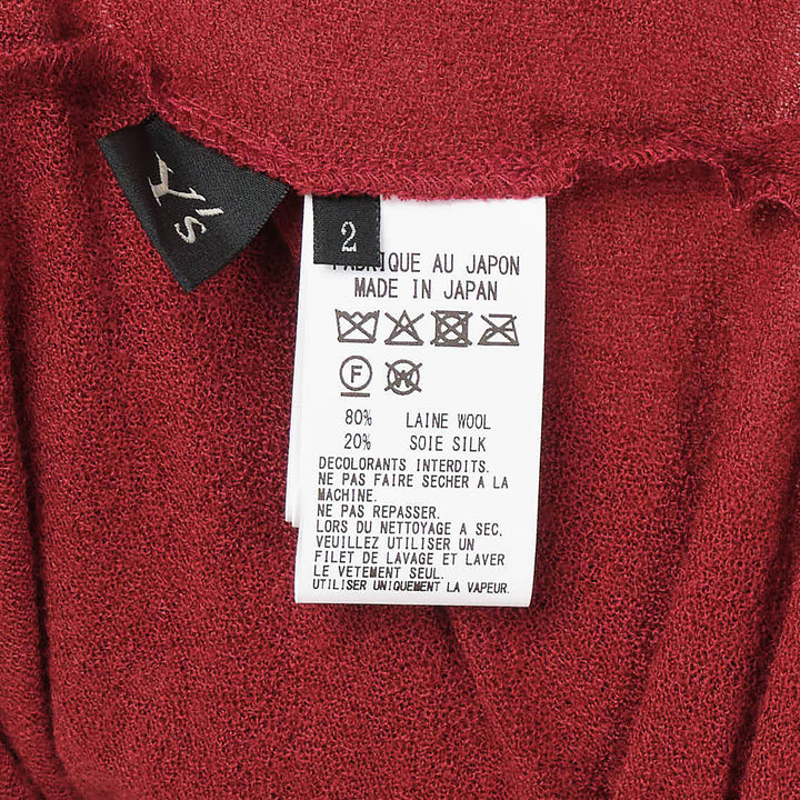 Y's red lightweight knit boat neck top with dark gunmetal buttons running along the full length of both long sleeves, shown flat on a white background - view 5