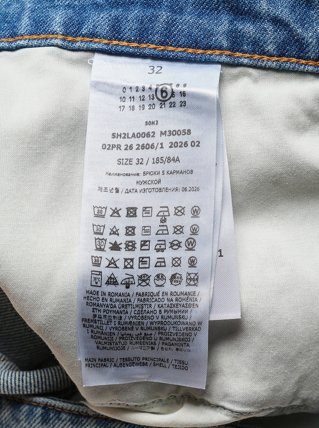 MM6 Maison Margiela light wash blue straight-leg jeans with a deconstructed asymmetric waistband and button fly, shown front view - view 4