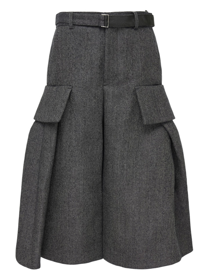 sacai Double-Faced Herringbone Midi Skirt in charcoal grey, featuring voluminous pleats, dual cargo patch pockets, and a black leather adjustable belt at the waist