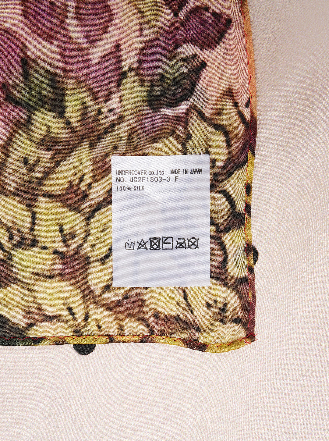 Undercover square scarf featuring a censored fawn with a green bow on a polka dot ground, framed by a red and green floral forest border - view 2