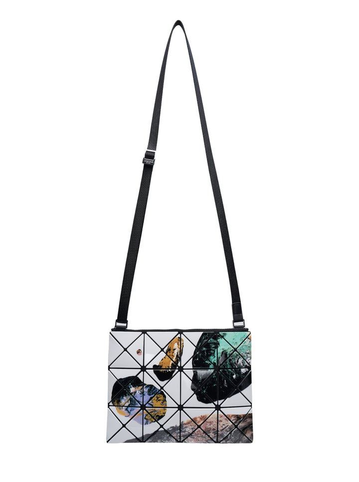 Bao Bao Issey Miyake Cosmic Crossbody Bag with geometric triangulated tile panels featuring an abstract photographic print in white, black, teal, and gold, with an adjustable black strap and silver-tone hardware