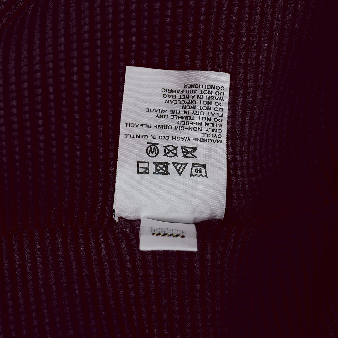me Issey Miyake Stretch Pleats 2 sleeveless top in deep burgundy, featuring all-over micro-pleated texture, a high stand collar with centre V-notch, and a broad structured shoulder line