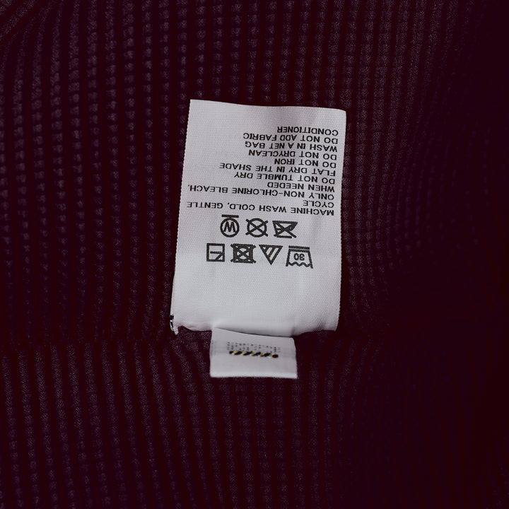 me Issey Miyake Stretch Pleats 2 sleeveless top in deep burgundy, featuring all-over micro-pleated texture, a high stand collar with centre V-notch, and a broad structured shoulder line
