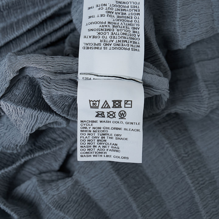 me Issey Miyake Accordion See-Through Crepe top in dusty blue, featuring horizontal accordion pleating, oversized boxy silhouette, elbow-length sleeves, and a gathered ruched hem, photographed flat on a white background