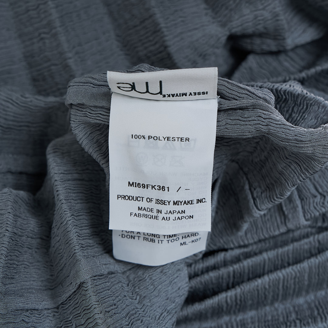 me Issey Miyake Accordion See-Through Crepe top in dusty blue, featuring horizontal accordion pleating, oversized boxy silhouette, elbow-length sleeves, and a gathered ruched hem, photographed flat on a white background