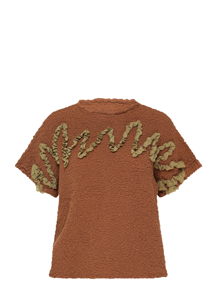 me Issey Miyake Leaf Tulle Cauliflower Top in rust brown bouclé with sage green ruffled tulle script lettering across the chest and sleeves, short sleeves with matching tulle stripe detailing and frilled neckline