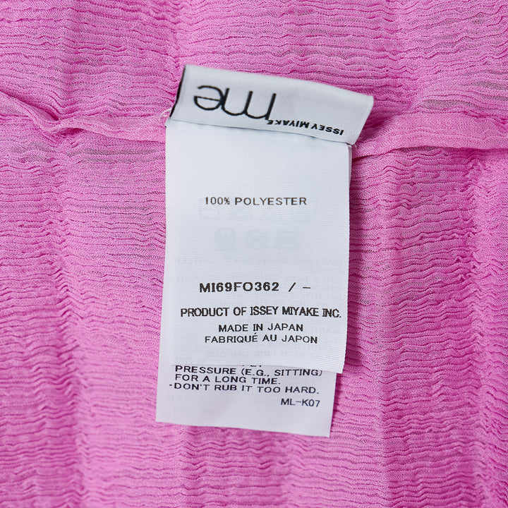 me Issey Miyake Accordion See-Through Crepe Cardigan in pink, featuring horizontal accordion pleating, ruffled lettuce-edge trim, dark contrast button-through front, and a relaxed long-sleeve silhouette