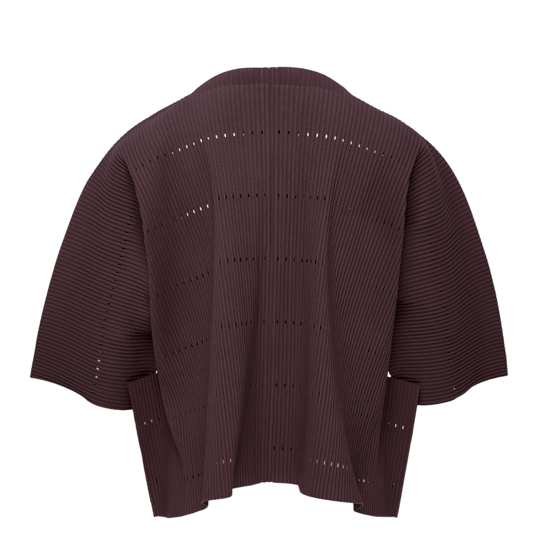 me Issey Miyake Tower Pleats Cardigan in cobalt blue, back view, featuring radiating openwork cutouts, tonal buttons, patch hip pockets, and cropped elbow-length sleeves