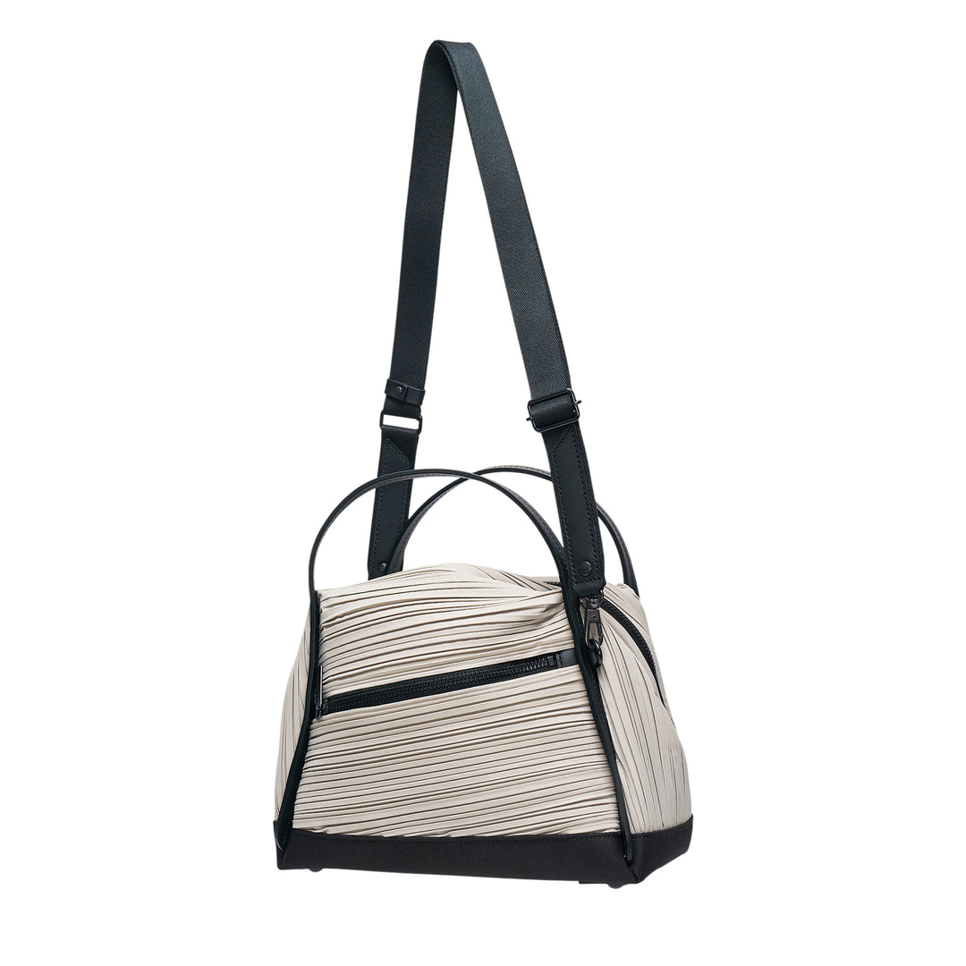 Pleats Please Issey Miyake Bias Pleats Crossbody Bag in black, showing diagonal pleated fabric body, dual top handles, and adjustable webbing shoulder strap on white background