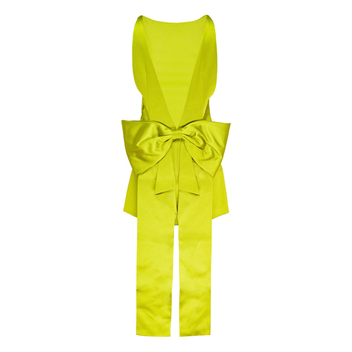 Self-Portrait lime green satin halter mini dress with structured bow waist detail, styled with matching slim-cut coordinating trousers, flat lay on white background