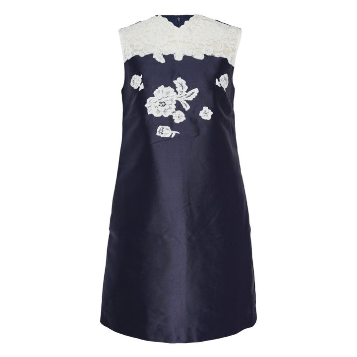 Self-Portrait navy taffeta mini dress with white guipure lace neckline yoke and floral lace appliqué on the front bodice, sleeveless A-line silhouette