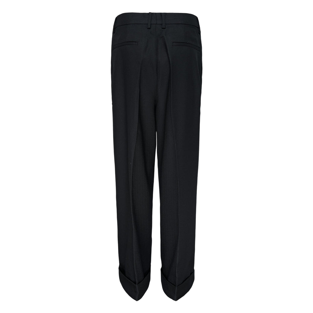 Melitta Baumeister Pointy Tailored Pants in black, featuring wide-leg silhouette, front pleats, thigh-level welt pocket, and sculptural pointed cuffed hem
