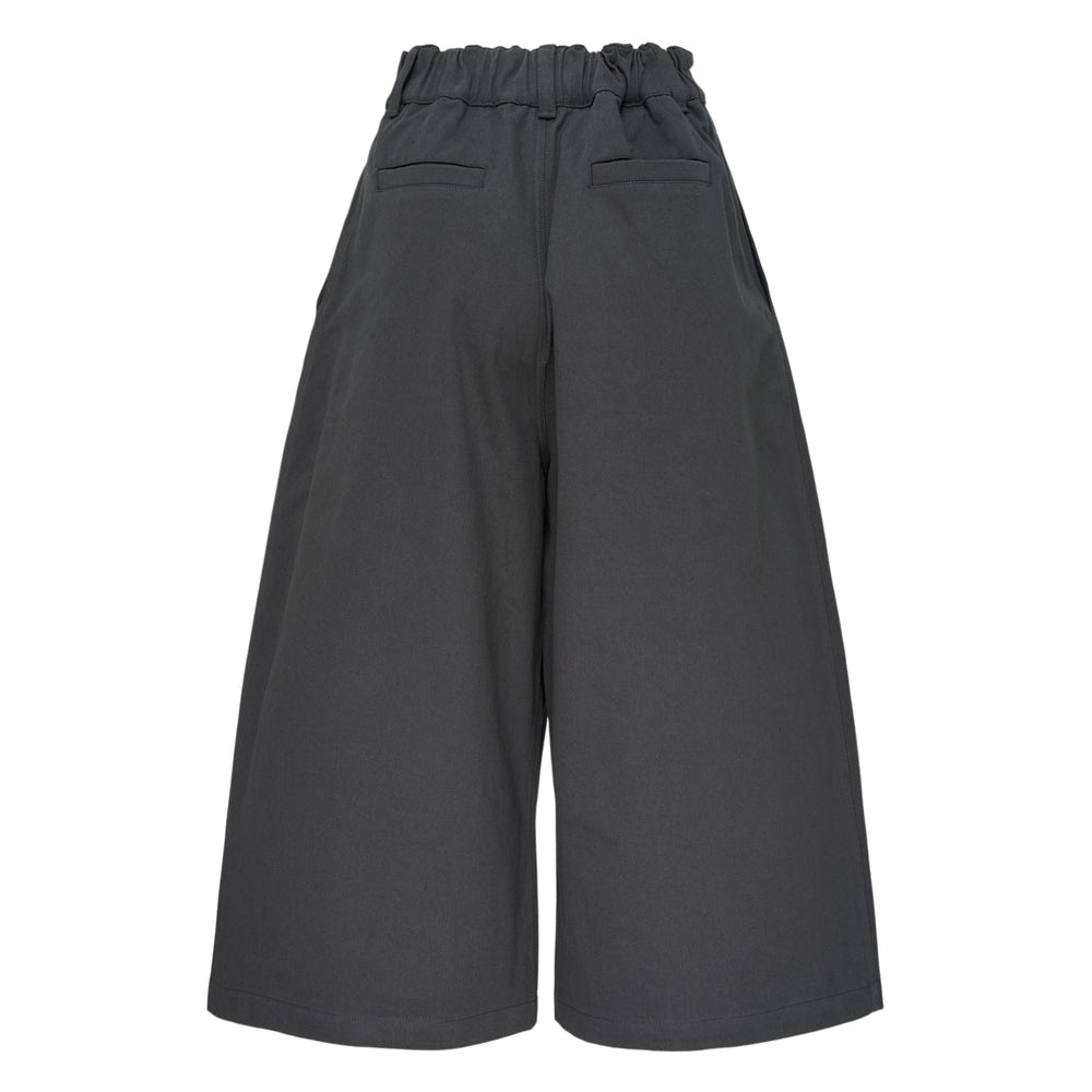 Melitta Baumeister charcoal wide-leg cargo culottes with high waist, sculptural rounded zip utility pocket, and A-line silhouette, shot flat on white background
