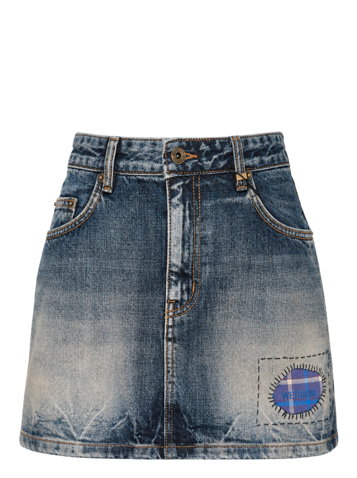 We11done Repaired Check Denim Mini Skirt in vintage-washed blue with contrast orange stitching, antique brass hardware, and an oval plaid check patch with embroidered We11done logo