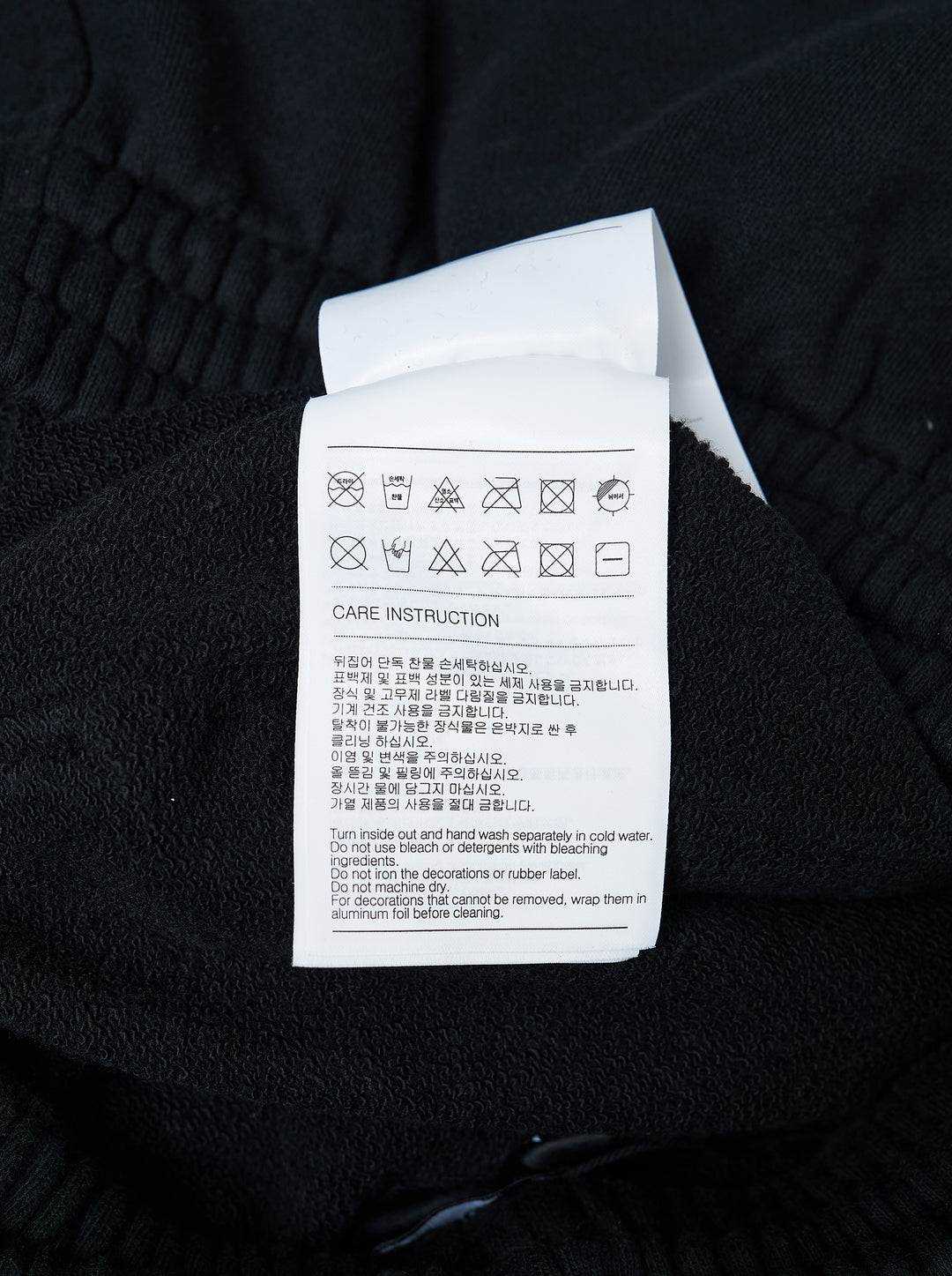 We11done Black Repaired Sweatpants with amber tartan plaid knee patch and embroidered logo, wide-leg relaxed fit, elasticated waistband, front view on white background - view 3