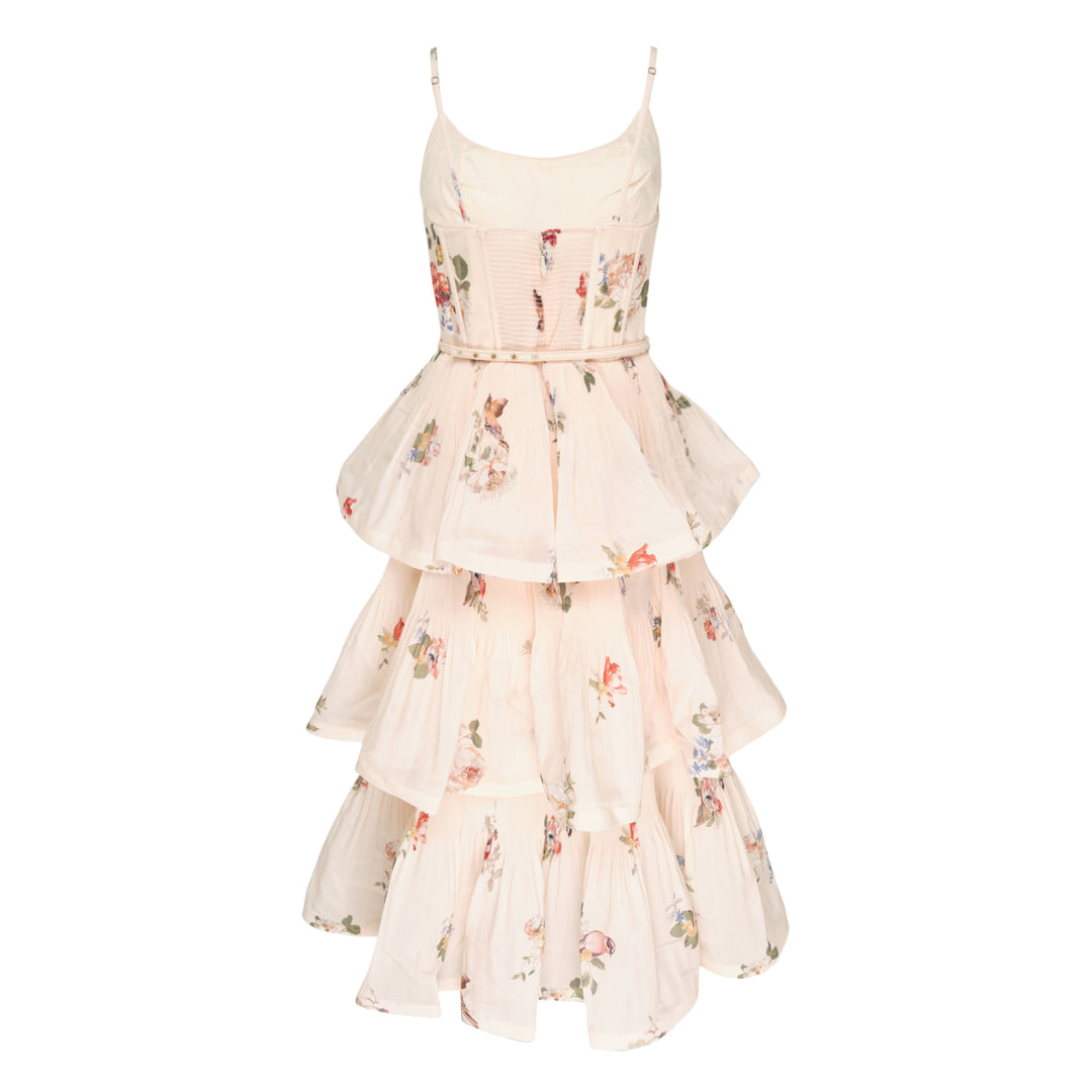 Zimmermann Pleated Tiered Midi Dress in blush floral print, featuring spaghetti straps, a pleated fitted bodice with bow detail, and four cascading ruffle tiers falling to a midi length
