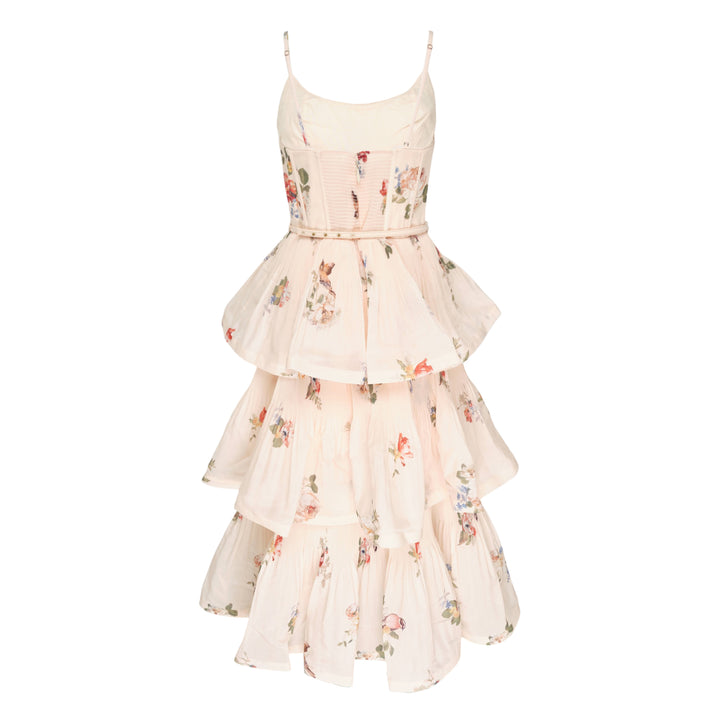 Zimmermann Pleated Tiered Midi Dress in blush floral print, featuring spaghetti straps, a pleated fitted bodice with bow detail, and four cascading ruffle tiers falling to a midi length